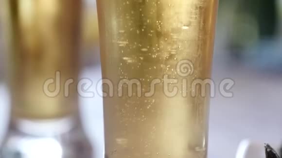 在装有水滴的玻璃杯里放冷光啤酒啤酒泡沫慢动作视频的预览图