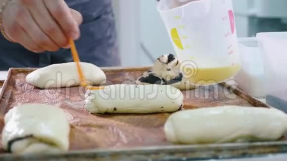 面包师在放入烤箱前对甜面进行润滑视频的预览图