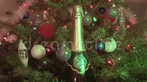 新的一瓶合适的香槟背景是装饰着玩具和圣诞杉树的花环视频的预览图