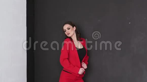 一位穿红色西装在照相馆摆姿势的商务女士视频的预览图