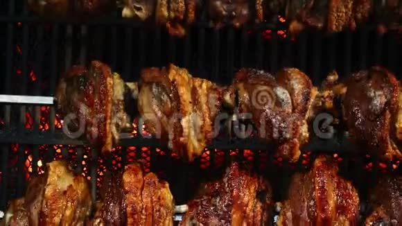旋转烤架上慢慢煮熟的猪肉指节视频的预览图