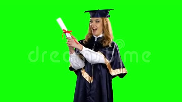 带毕业礼服和文凭的女孩绿色屏幕视频的预览图
