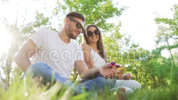 年轻夫妇在公园里和一个旋转手玩得很开心视频的预览图