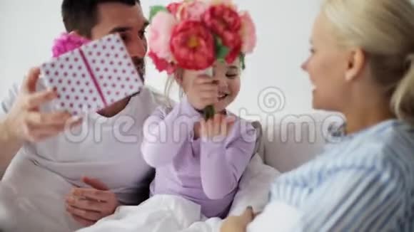 一家人在床上给母亲送花和礼物视频的预览图