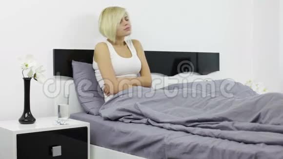 女人胃痛生病的女孩躺在床上抱着视频的预览图