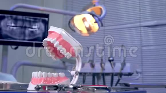 牙医桌上的牙齿模型仪器和背景中的全景x射线图像视频的预览图