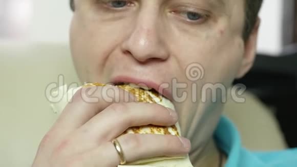 瘦削的男人吃快餐非常享受嚼垃圾食品的家伙胃口很大慢动作视频的预览图