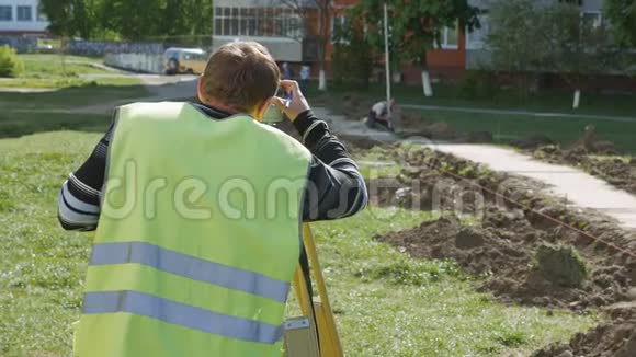 道路修复中的特种设备工作测量员在测量道路上的距离时视频的预览图