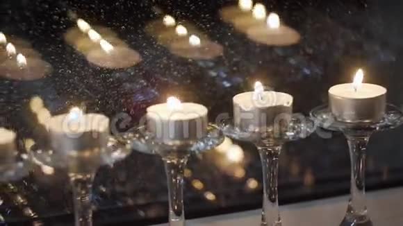 小蜡烛陈列在一个窗口里窗户上蜡烛的倒影蜡烛的火焰在风中摇曳许多视频的预览图