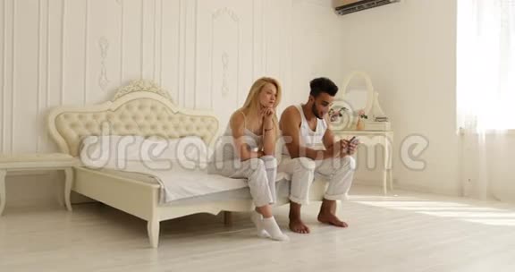 年轻夫妇关系问题冲突坐在床上争吵不开心混在一起男人女人消极情绪视频的预览图