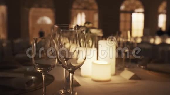 宴会厅桌上的空酒杯和点燃的蜡烛和盘子视频的预览图
