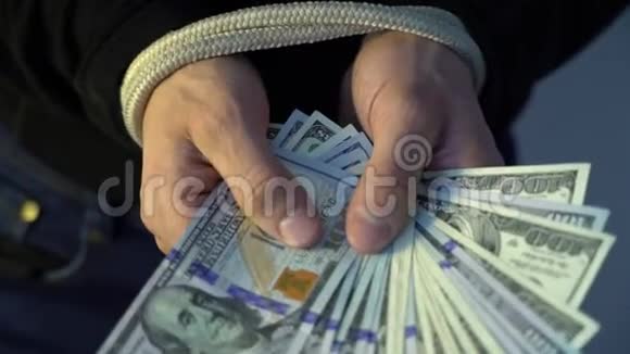 男性手握着绳子握着一堆钱美元钞票金融领域的概念视频的预览图