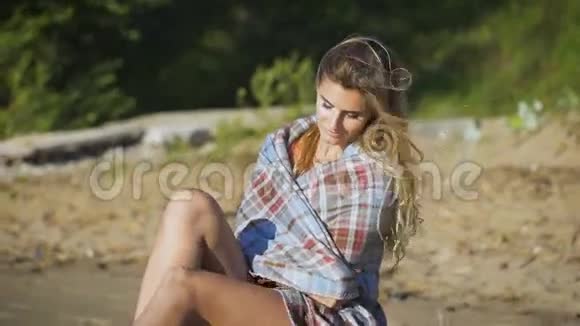 坐在木头上的漂亮女孩旅行和假期自由概念性感金发美女视频的预览图