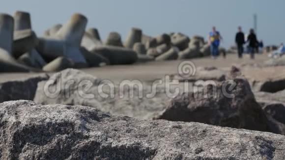 游客和游客在码头和防波堤的岩石上漫步到克拉西佩达港的入口处视频的预览图
