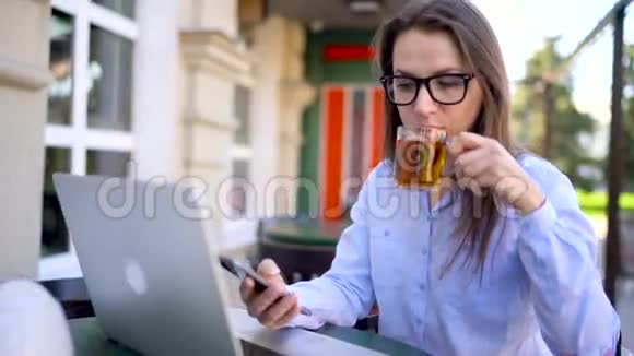 在户外咖啡馆工作的漂亮年轻女子视频的预览图