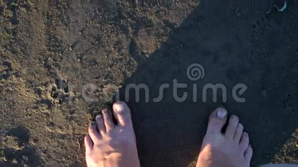 在湿沙上缓慢行走的人脚视频的预览图