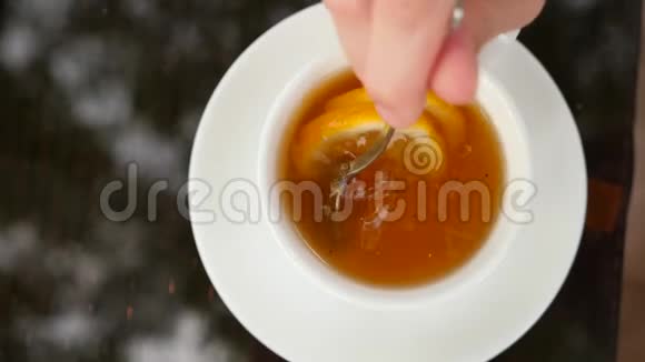 有人用绿茶在杯子里搅拌柠檬糖4K慢动作视频的预览图