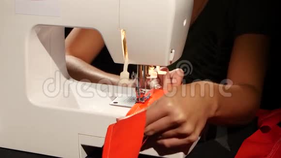 红色织物在缝纫机上缝制关门视频的预览图