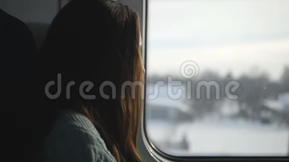 年轻女子坐火车时看着窗户在铁路上旅行的迷人女孩的形象慢动作视频的预览图