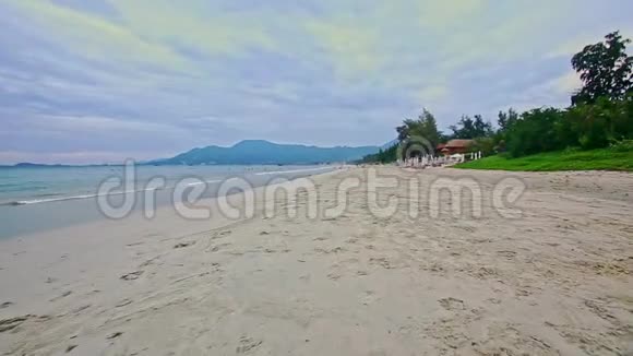 宽阔的白色沙滩海浪拍打蓝天视频的预览图