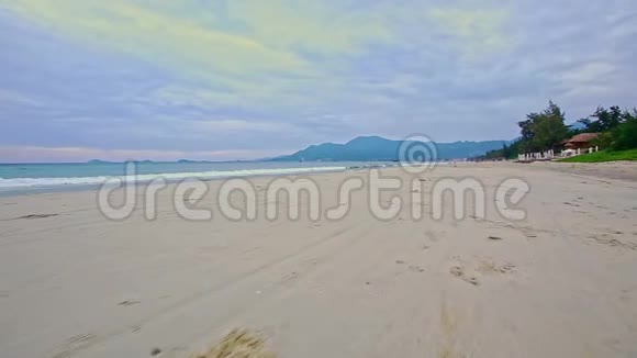 宽阔的白色沙滩海浪拍打蓝天视频的预览图