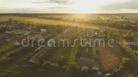 俄罗斯村庄上空美丽的日落周围的田野和树木空中和视频拍摄视频的预览图