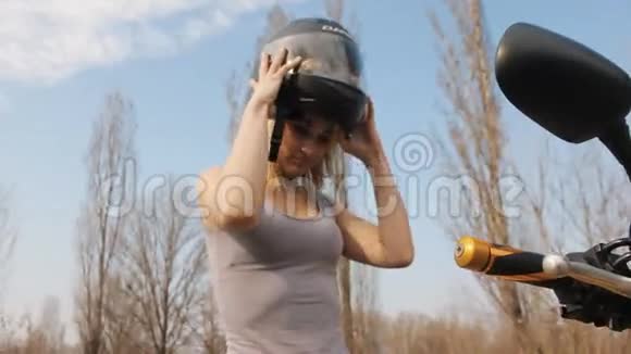 摩托车上的女孩摘下她的头盔慢动作视频的预览图