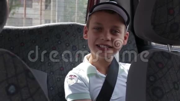 坐在汽车后座上的男孩系着安全带视频的预览图