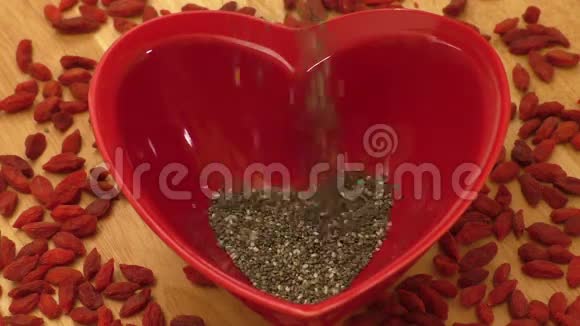 心形陶瓷碗中的辣椒种子和干果酱浆果视频的预览图