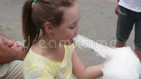 开朗的小女孩正在吃棉花糖特写视频的预览图