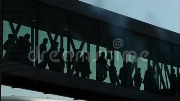 在机场登机桥上行走的乘客视频的预览图