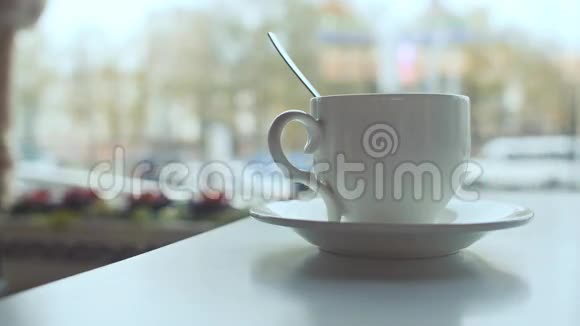 白色咖啡杯放在桌子上咖啡放在背景窗上视频的预览图