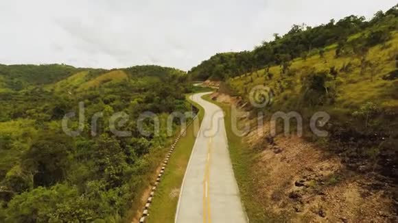 一条蜿蜒的长路穿过青山布桑加岛死因空中观景菲律宾视频的预览图