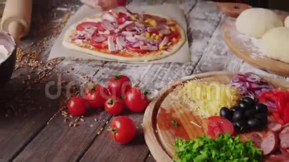 女人在厨房里做披萨的时候把配料放在面团上视频的预览图