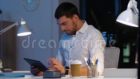 有平板电脑的商人在夜间办公视频的预览图