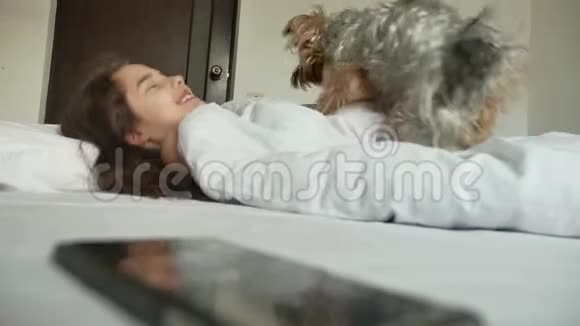小可爱的女孩和狗睡在床上小女孩睡在床上室内的生活方式很有趣视频的预览图