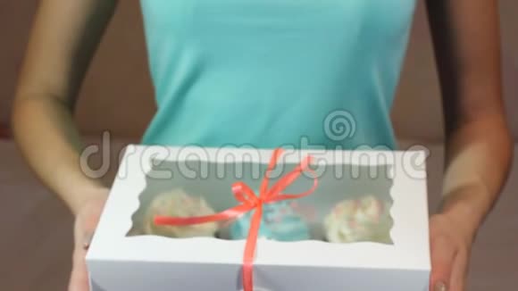装饰礼品盒与纸杯蛋糕系在一起女性手中有一条绿松石丝带视频的预览图