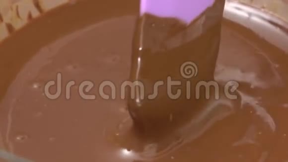 在玻璃碗中加入奶油和搅拌融化的巧克力视频的预览图
