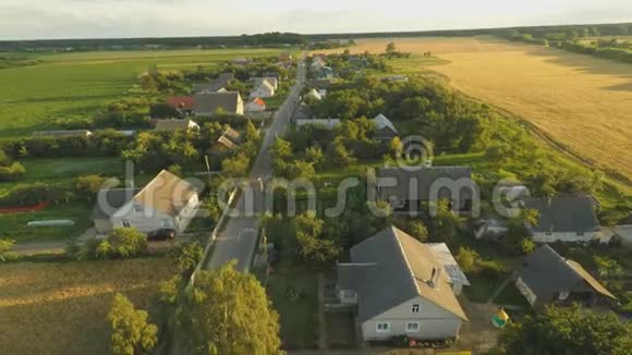 俄罗斯村庄上空美丽的日落周围的田野和树木空中和视频拍摄视频的预览图