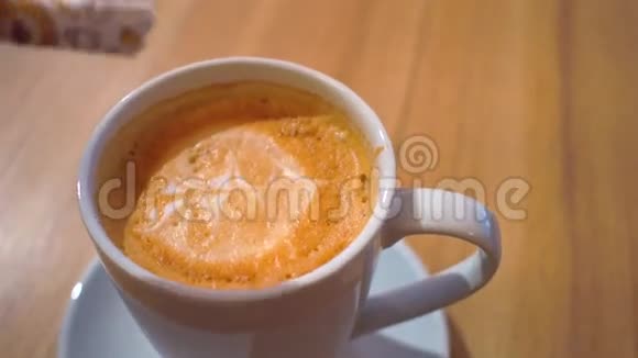 在卡布奇诺中加入糖并搅拌咖啡杯近4K镜头视频的预览图