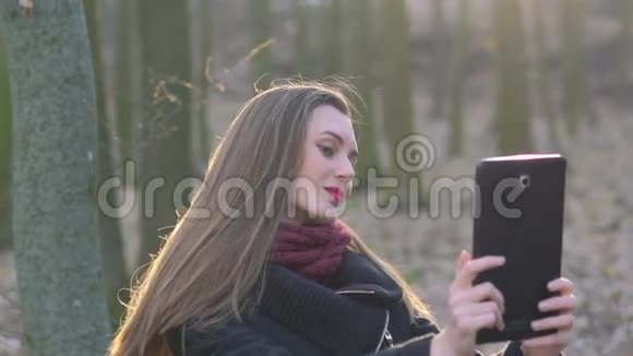 美丽的女孩在阳光明媚的森林里自拍视频的预览图