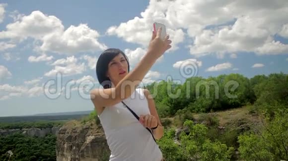 有魅力的女人在山里的智能手机上自拍视频的预览图