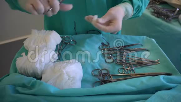 外科医生戴着蓝色手套准备手术前的器械擦拭手术夹视频的预览图