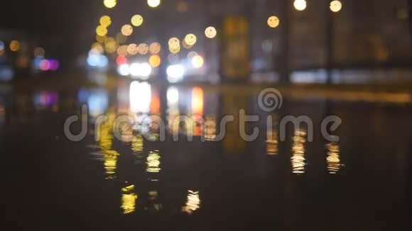 夜间城市街道上有小雨点灯光在水中闪烁视频的预览图