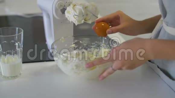女人的手打破鸡蛋把它们倒入碗里视频的预览图