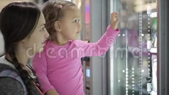 母女俩在机场内的自动售货机里挑选零食视频的预览图