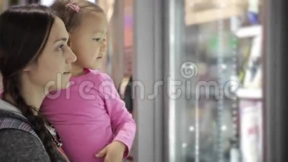 母女俩在机场内的自动售货机里挑选零食视频的预览图