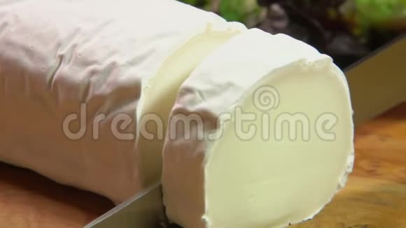 一块带有灰模的山羊奶酪用刀切视频的预览图