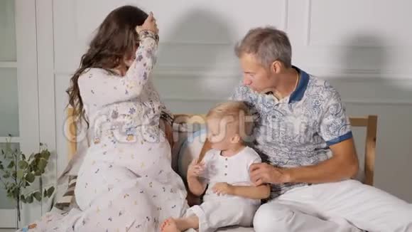 幸福的孕妇有家人在床上视频的预览图