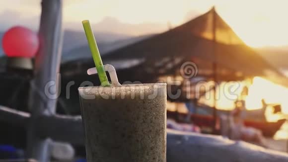 日落时分在海滩咖啡馆喝一杯鸡尾酒在海中划船1920x1080视频的预览图